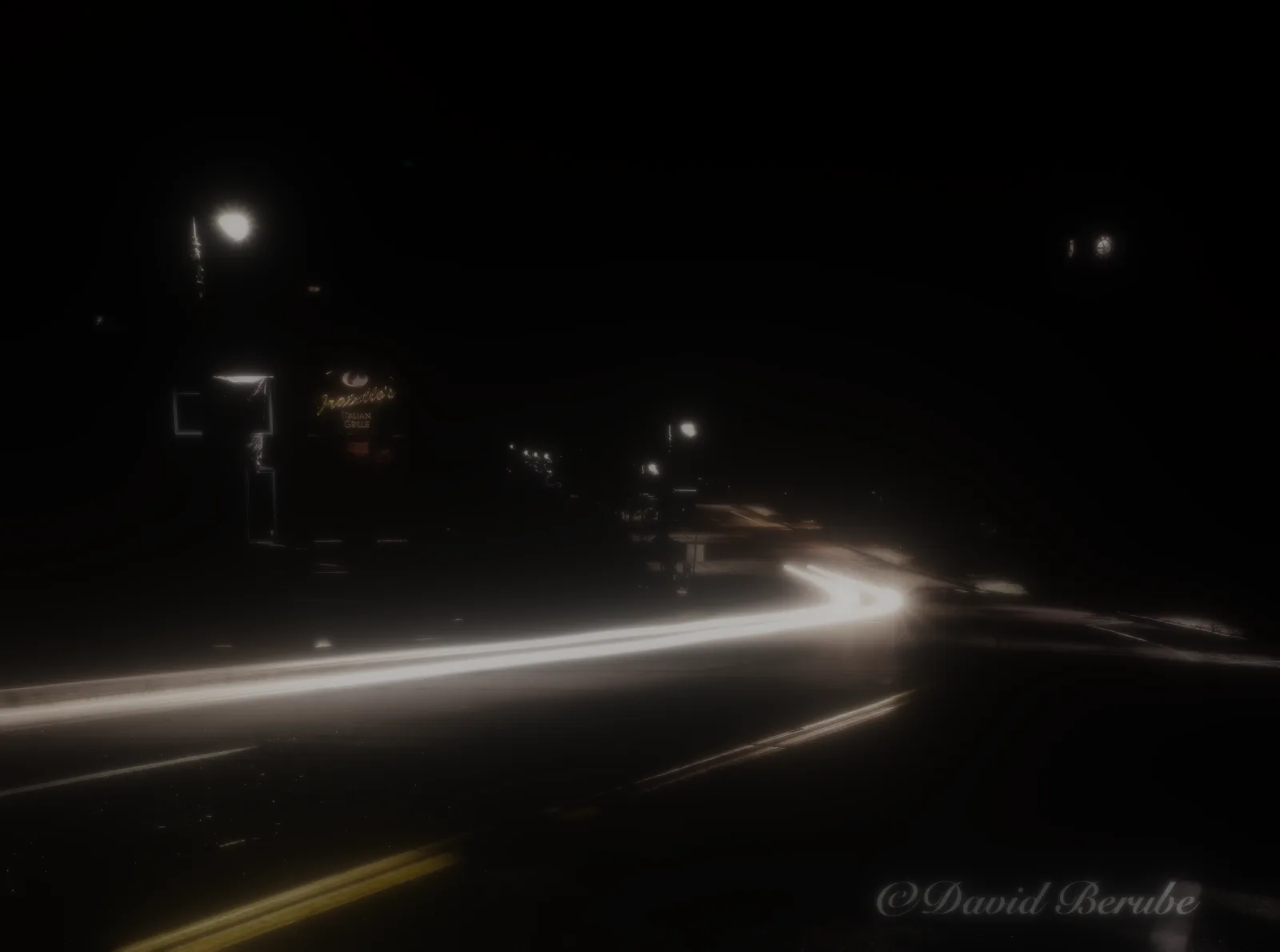 The glow from the night street alone, on black.