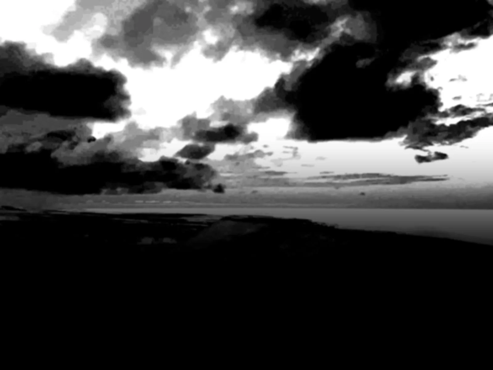 A white sky mask over black land.
